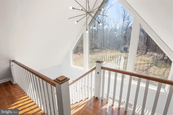 a view of a hallway with wooden floor and windows