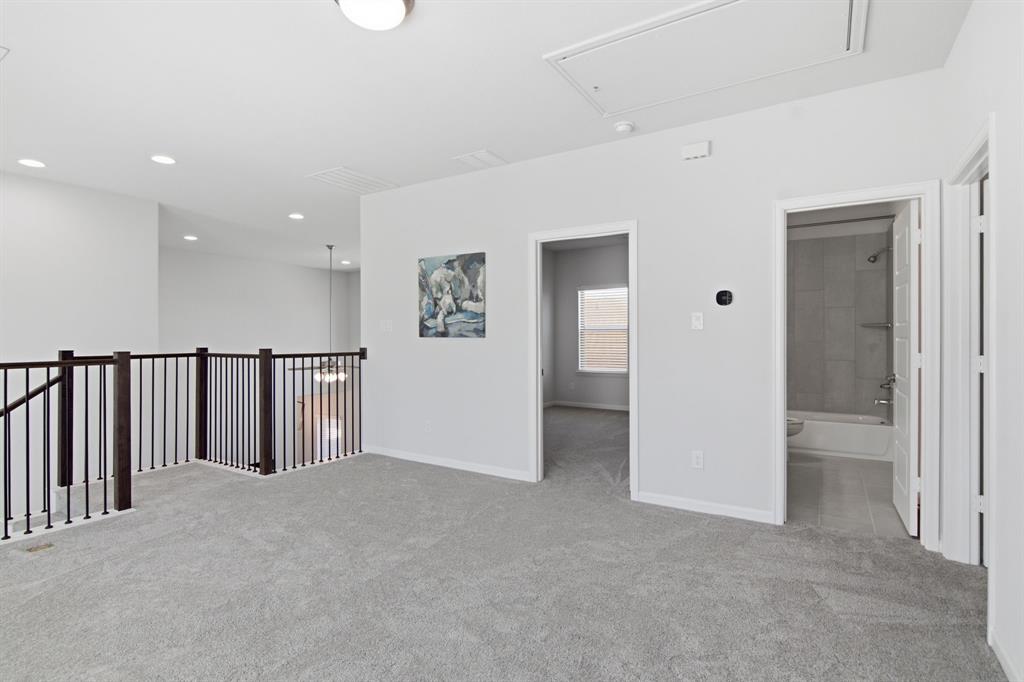 201 Pintail Lane Rhome, TX 76078 - Photo 20 of 36 Carpeted upper-level landing featuring a wood and metal baluster railing, recessed lighting, and a visible attic access panel