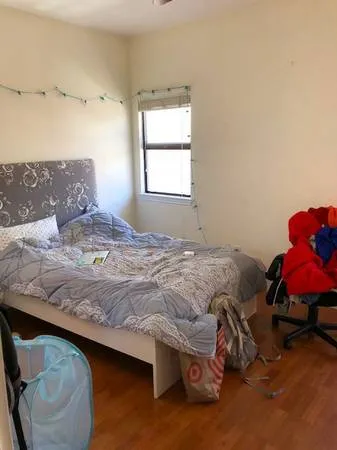 a bedroom with a bed and a window