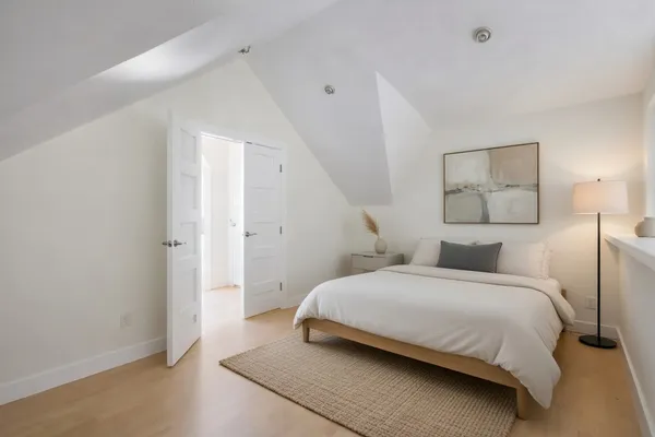a bedroom with a bed and a painting on the wall