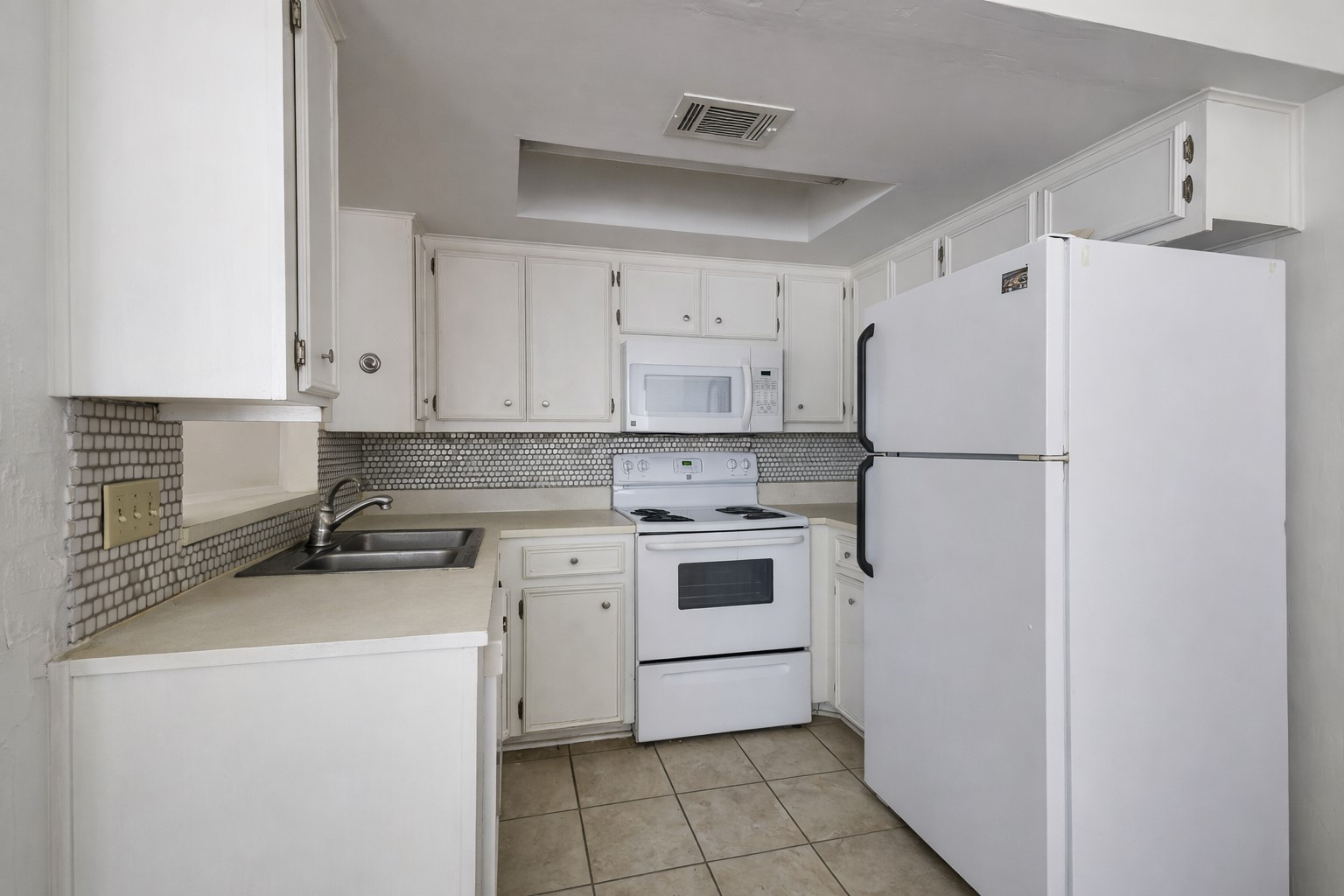 706 West 22nd Street, Unit 306 Austin, TX 78705 - Photo 5 of 19 a kitchen with a refrigerator a stove a sink and white cabinets