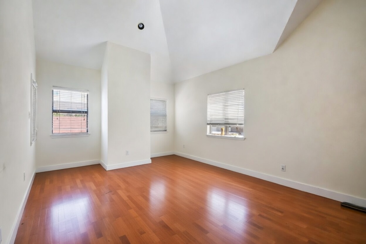 706 West 22nd Street, Unit 306 Austin, TX 78705 - Photo 10 of 19 an empty room with wooden floor and windows