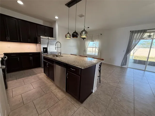 a kitchen with stainless steel appliances granite countertop a stove a sink dishwasher and a refrigerator