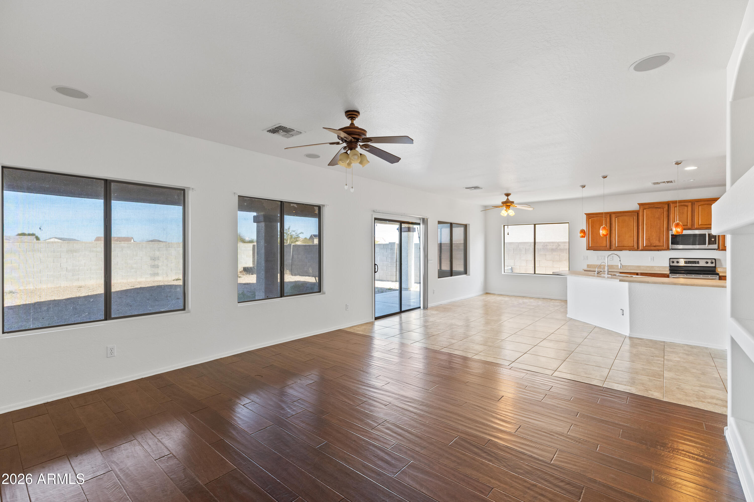 9840 Tangerine Road Florence, AZ 85132 - Photo 5 of 38 a view of an empty room with window and wooden floor