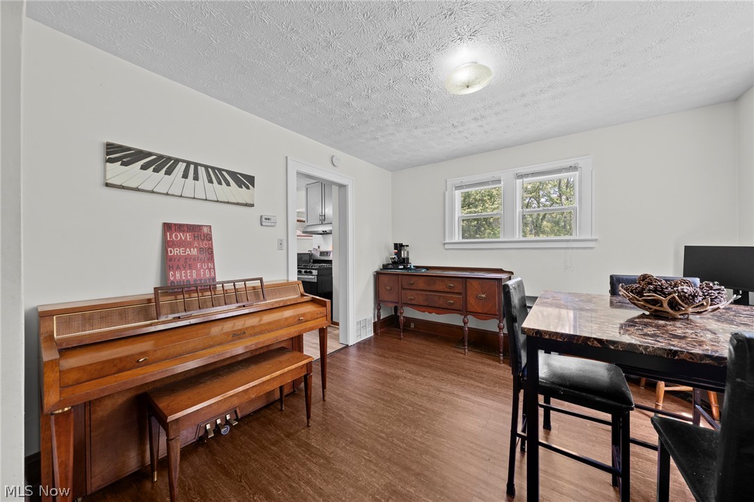 819 Keeney Street Akron, OH 44310 - Photo 11 of 24 Spacious room featuring wood-finish flooring, white walls, and a textured ceiling