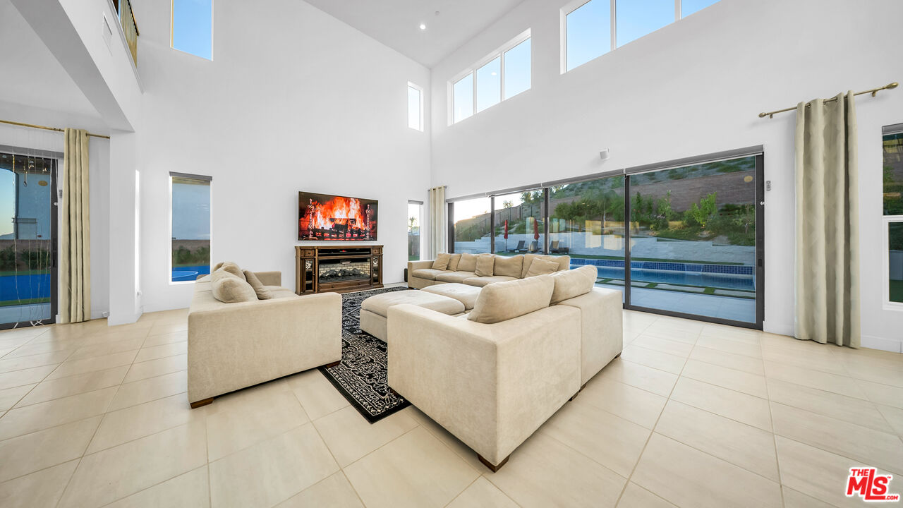 12553 Ridgeline Road Porter Ranch, CA 91326 - Photo 22 of 53 a living room with furniture a large window and a flat screen tv