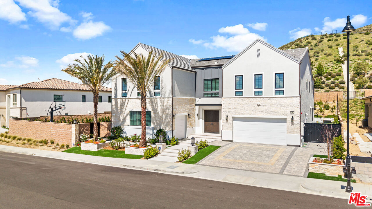 12553 Ridgeline Road Porter Ranch, CA 91326 - Photo 6 of 53 a front view of a house with a garden