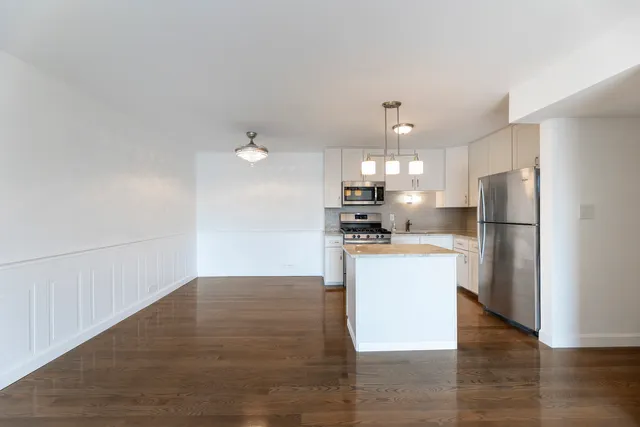 a kitchen with a refrigerator and a stove top oven