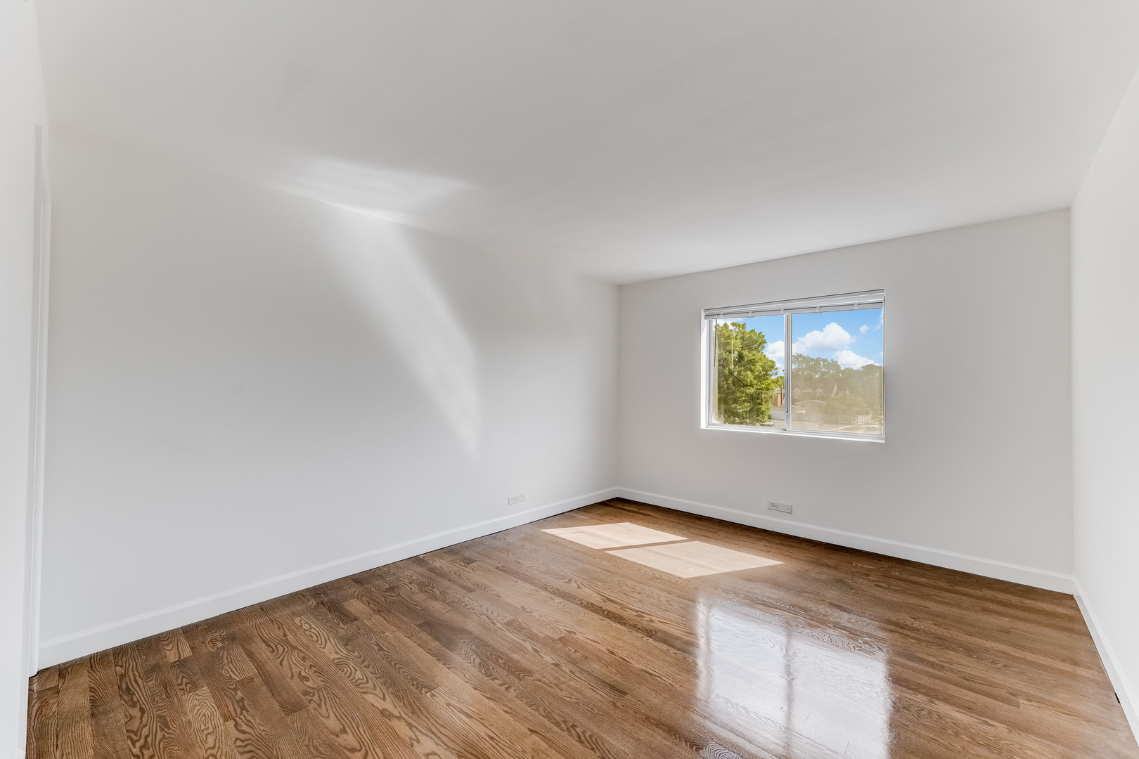 9820 South Pulaski Road, Unit 213 Oak Lawn, IL 60453 - Photo 8 of 15 an empty room with wooden floor and window