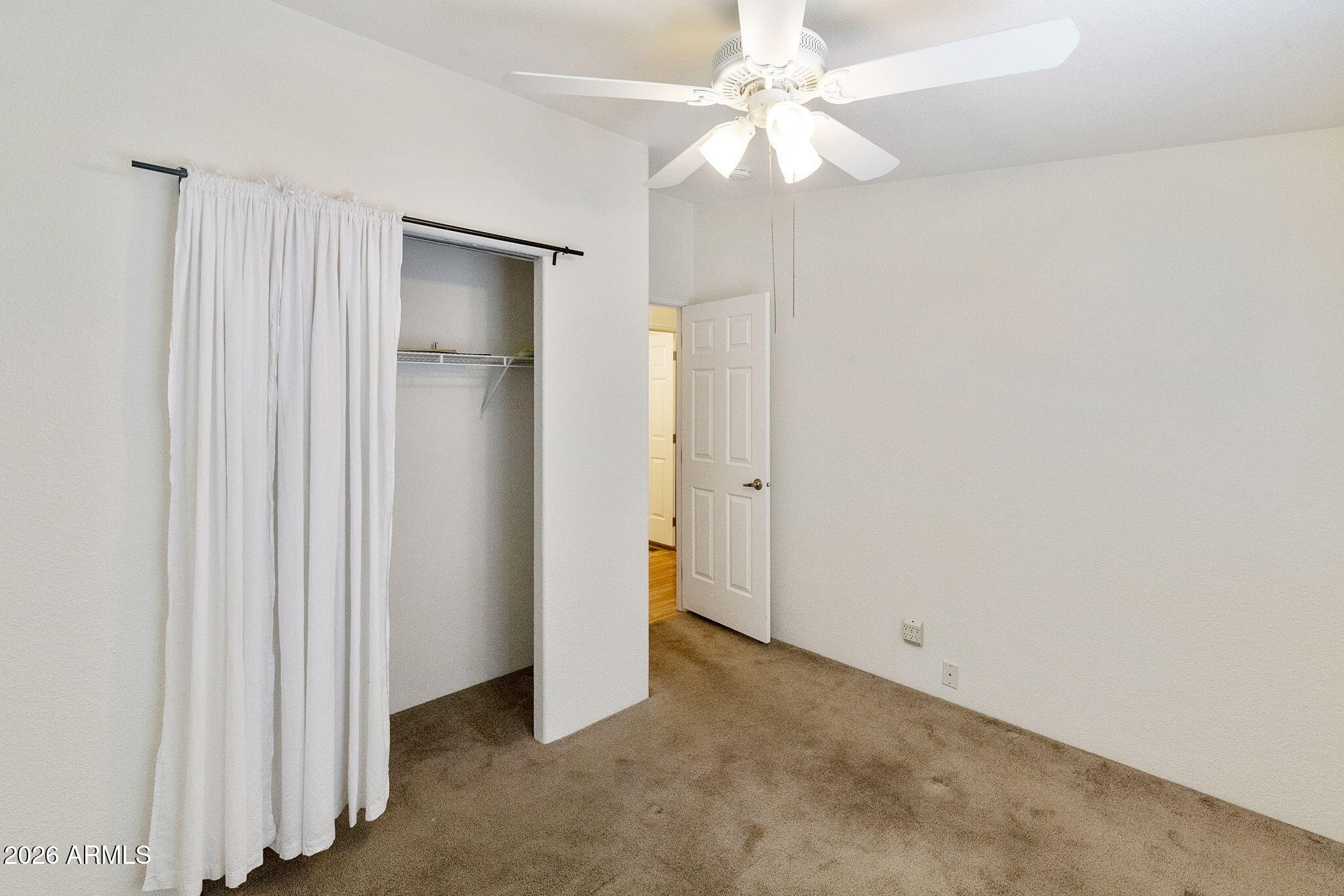 3700 South Tomahawk Road, Unit 93 Apache Junction, AZ 85119 - Photo 18 of 32 an empty room with a ceiling fan and a window
