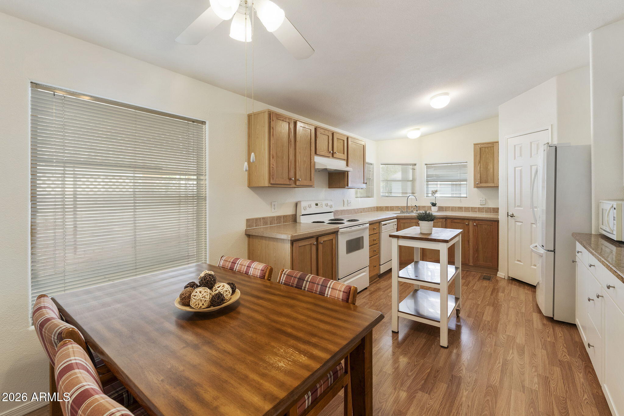 3700 South Tomahawk Road, Unit 93 Apache Junction, AZ 85119 - Photo 28 of 32 a kitchen with stainless steel appliances kitchen island granite countertop a table chairs sink and cabinets