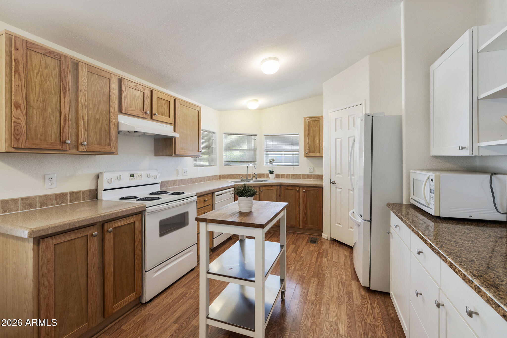 3700 South Tomahawk Road, Unit 93 Apache Junction, AZ 85119 - Photo 29 of 32 a kitchen with a stove a sink and a refrigerator