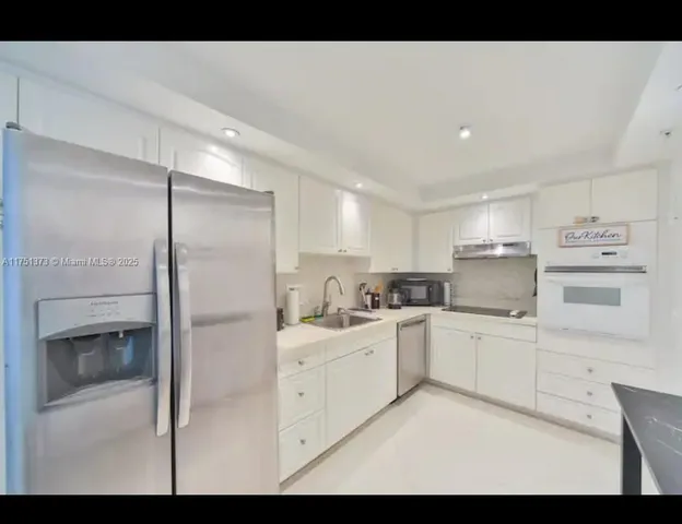 a kitchen with white cabinets and white appliances