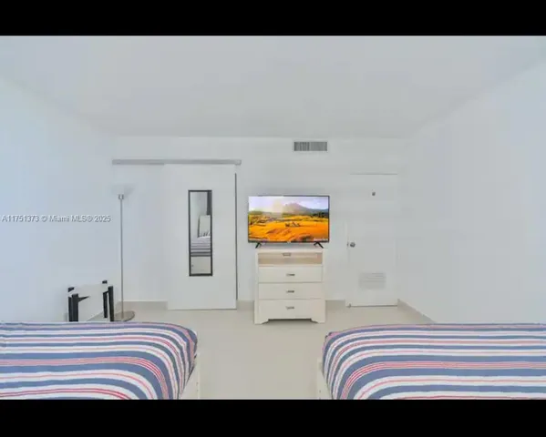 a bedroom with a bed and two windows