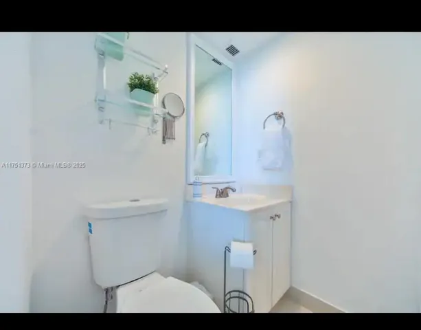 a bathroom with a sink and mirror with toilet