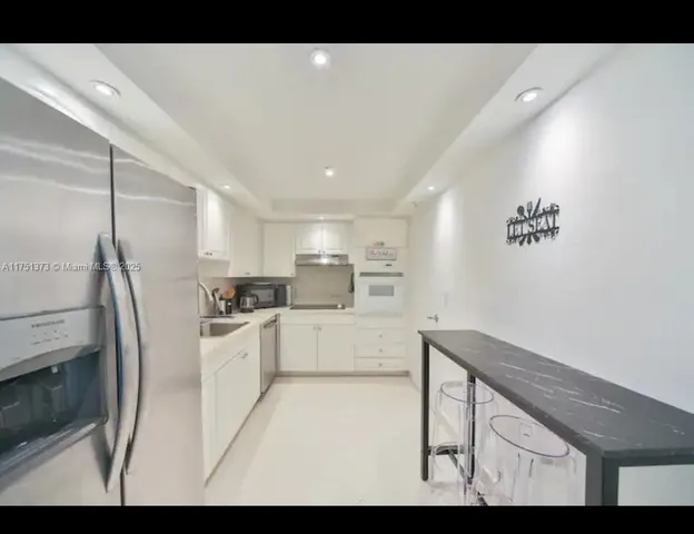 a kitchen with refrigerator and cabinets