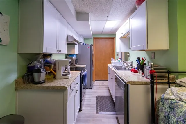 a kitchen with stainless steel appliances granite countertop a sink stove and refrigerator
