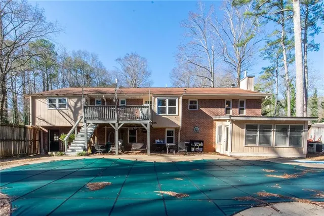 a view of a patio with a table chairs and a small yard