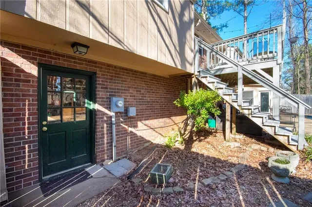 a view of a patio with table and chairs potted plants with wooden floor and fence