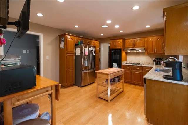 a open kitchen with stainless steel appliances granite countertop a stove and a refrigerator