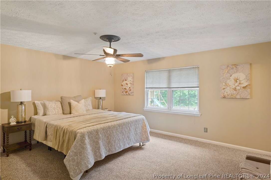 6481 Green Meadow Road Fayetteville, NC 28304 - Photo 24 of 33 a bedroom with a bed and a chandelier