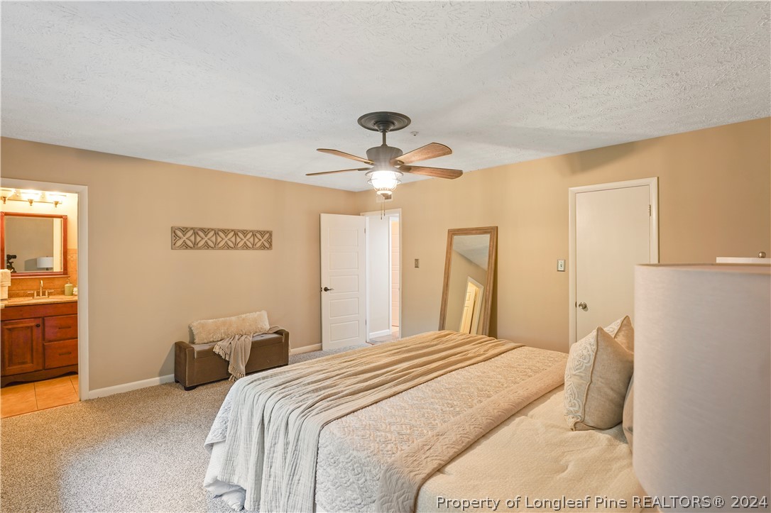 6481 Green Meadow Road Fayetteville, NC 28304 - Photo 25 of 33 a bedroom with a bed and a chandelier