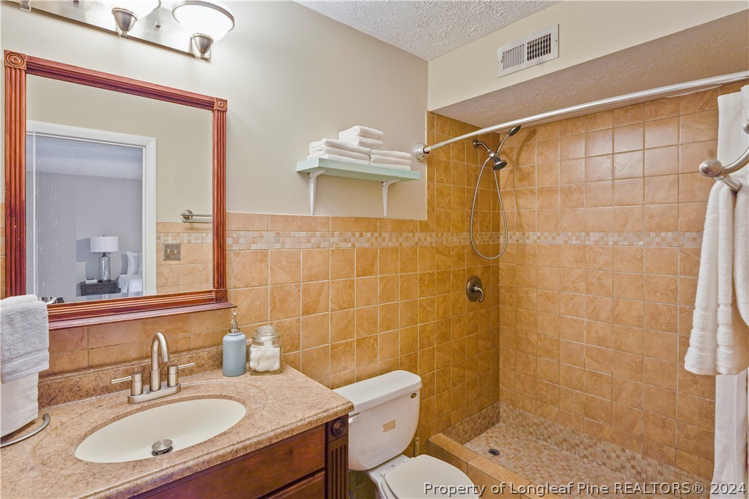 6481 Green Meadow Road Fayetteville, NC 28304 - Photo 26 of 33 a bathroom with a sink toilet a mirror and shower