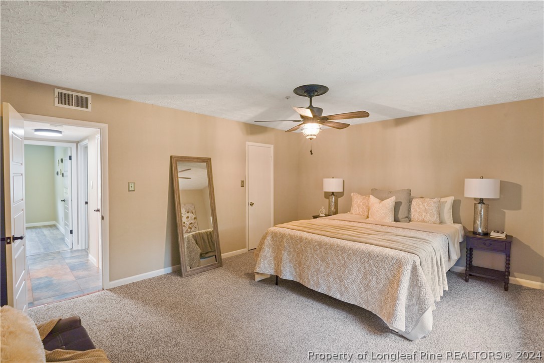 6481 Green Meadow Road Fayetteville, NC 28304 - Photo 27 of 33 a bedroom with a bed and a chandelier