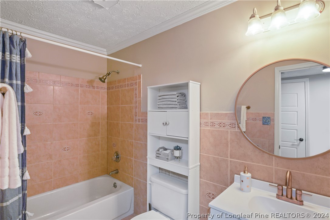 6481 Green Meadow Road Fayetteville, NC 28304 - Photo 28 of 33 a bathroom with a tub shower vanity and a sink