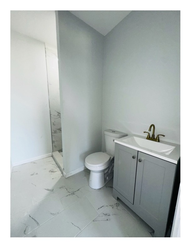 63 Water Street, Unit 33 Torrington, CT 06790 - Photo 4 of 5 a bathroom with a toilet a sink and mirror