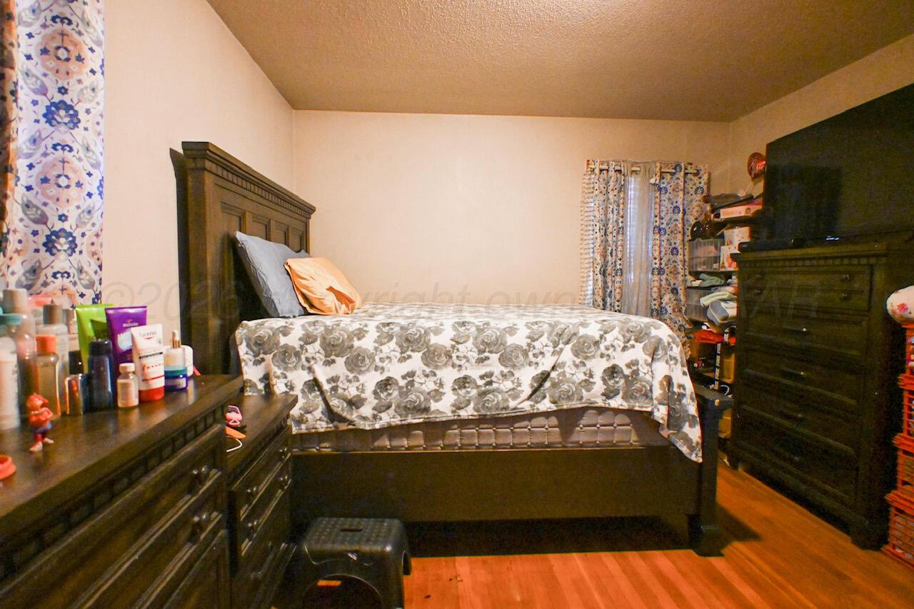 1313 Southwest 15th Avenue Amarillo, TX 79102 - Photo 12 of 15 a bed sitting in a bedroom next to a flat tv screen tv on a dresser