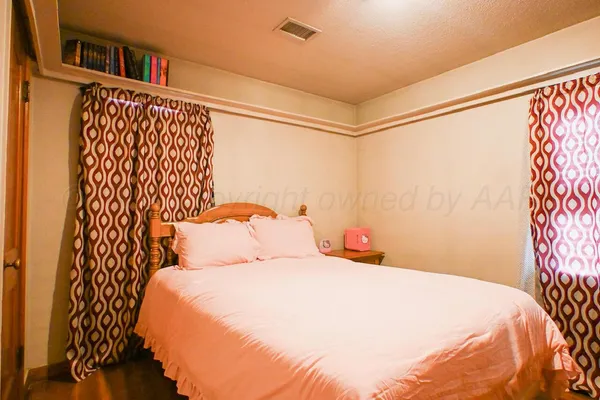 a bedroom with a bed and a potted plant