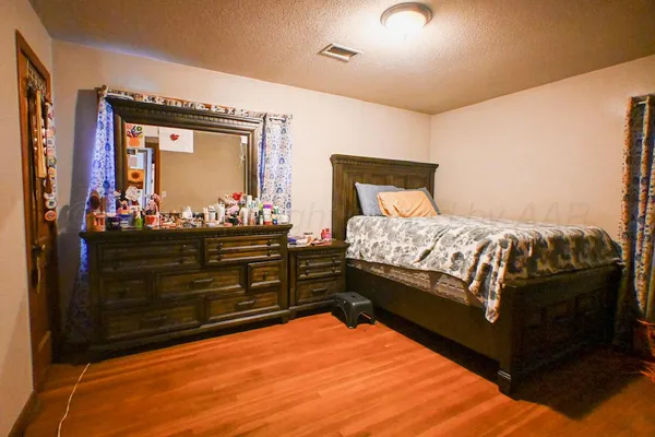 a bedroom with a bed and dresser with mirror