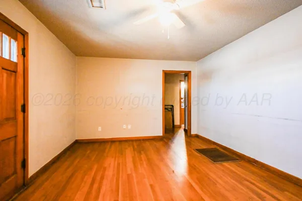 a view of empty room with wooden floor