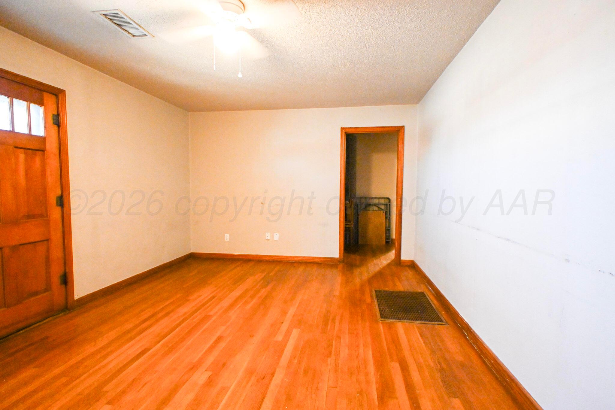 1313 Southwest 15th Avenue Amarillo, TX 79102 - Photo 8 of 15 a view of an empty room with wooden floor and a window