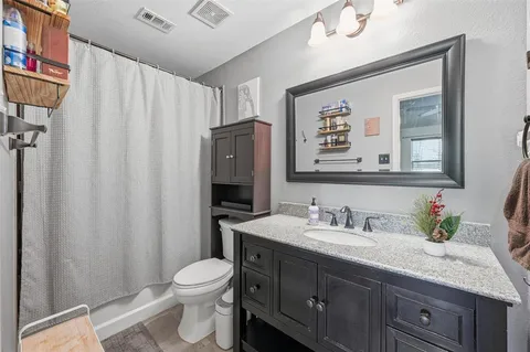 a bathroom with a granite countertop sink toilet and shower