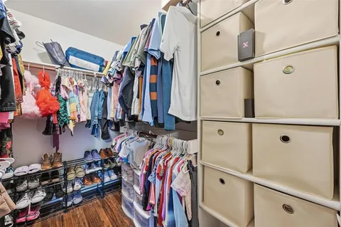 a view of walk in closet with clothes and shoes