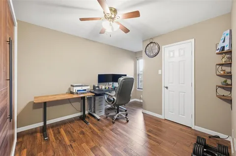 a view of a workspace with furniture and wooden floor