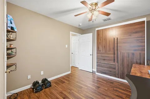 a very nice looking room with a ceiling fan and wooden floor