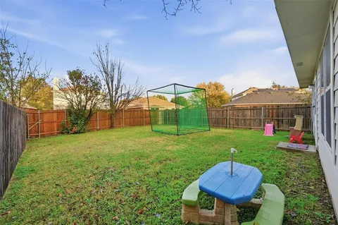 a view of a backyard with table and chairs potted plants and a palm tree