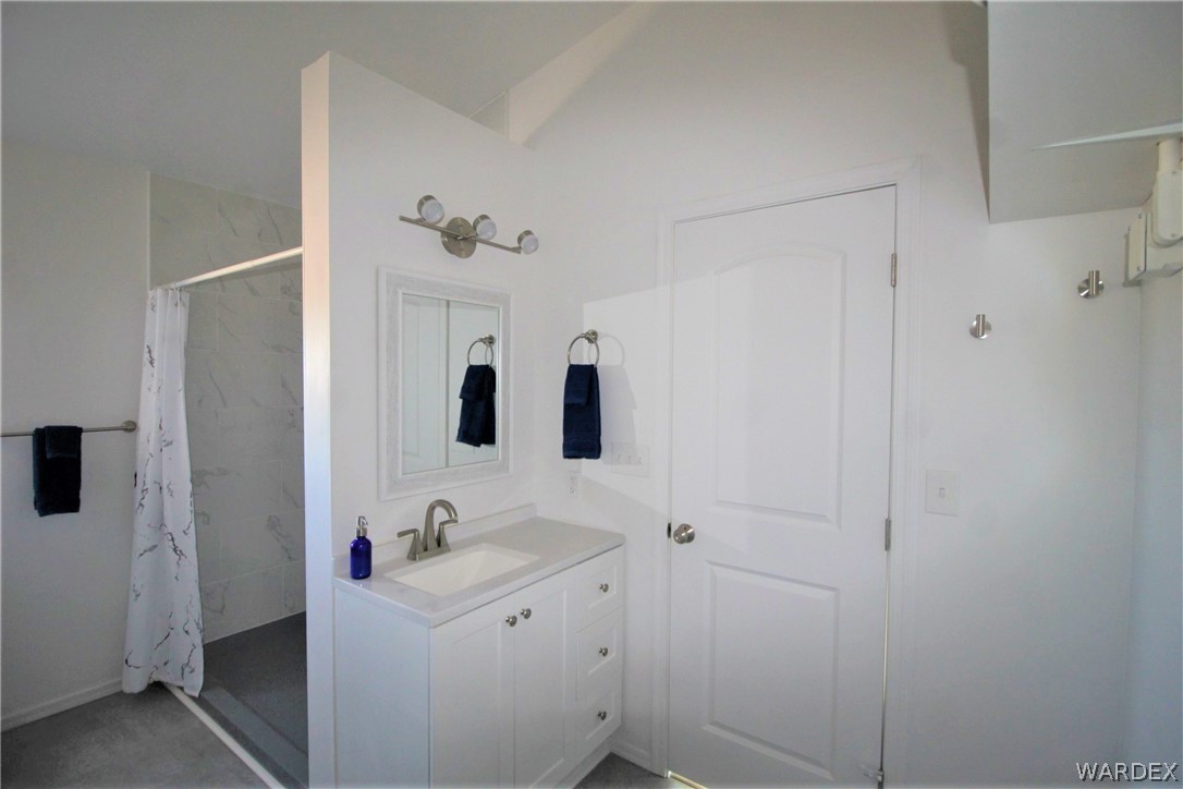11722 Suzette Road Yucca, AZ 86438 - Photo 14 of 29 a spacious bathroom with a shower sink and mirror