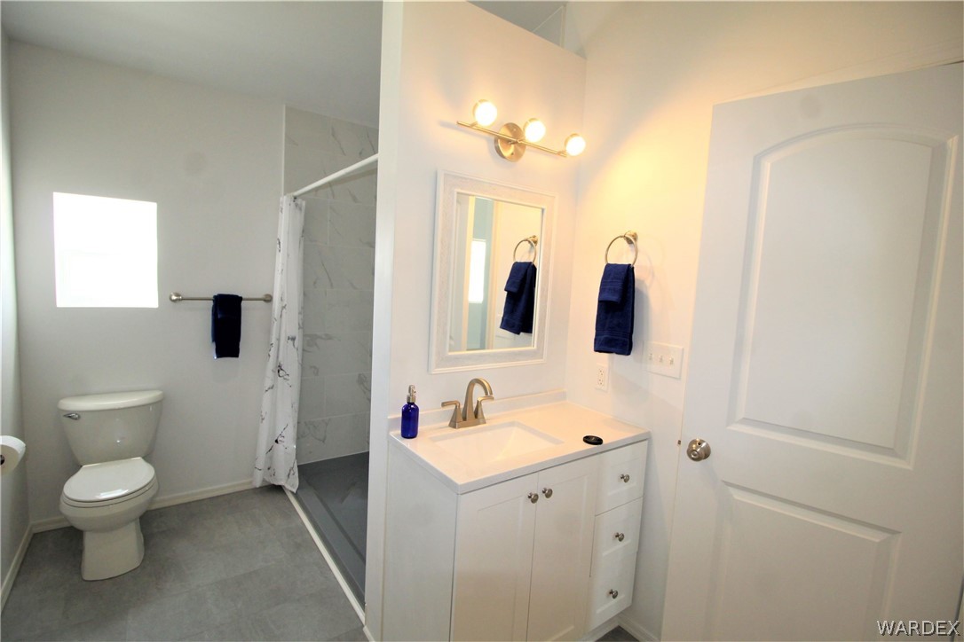11722 Suzette Road Yucca, AZ 86438 - Photo 16 of 29 a bathroom with a toilet sink a mirror and shower