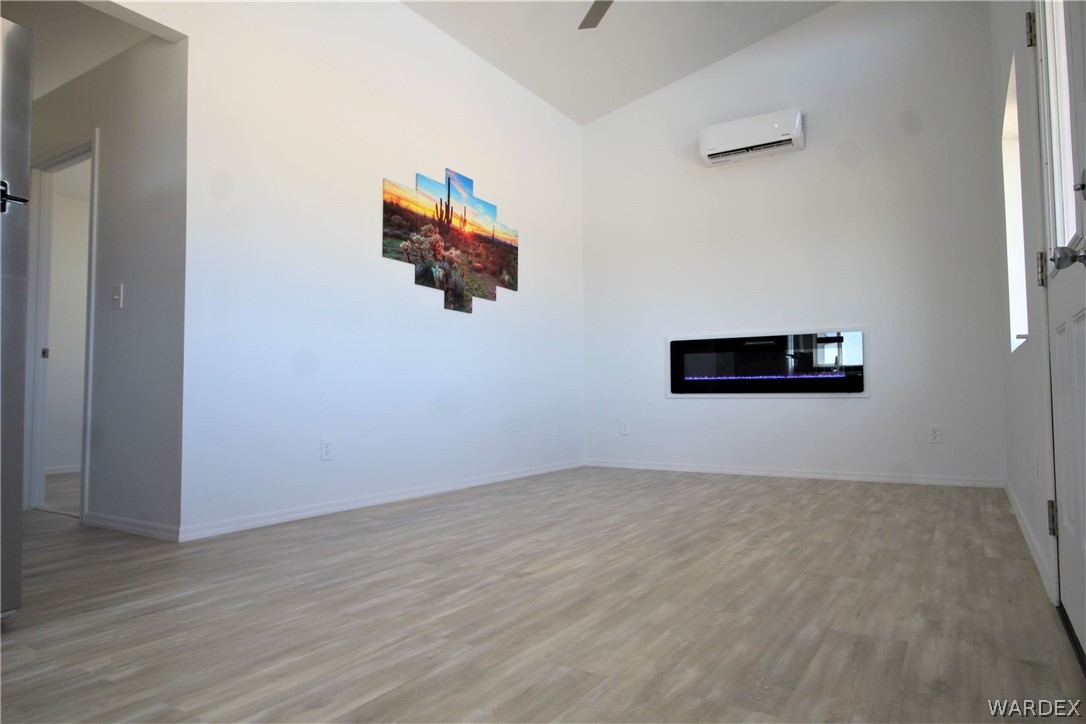 11722 Suzette Road Yucca, AZ 86438 - Photo 19 of 29 an empty room with wooden floor and white walls