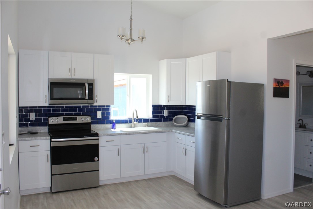 11722 Suzette Road Yucca, AZ 86438 - Photo 6 of 29 a kitchen with a refrigerator stove and microwave