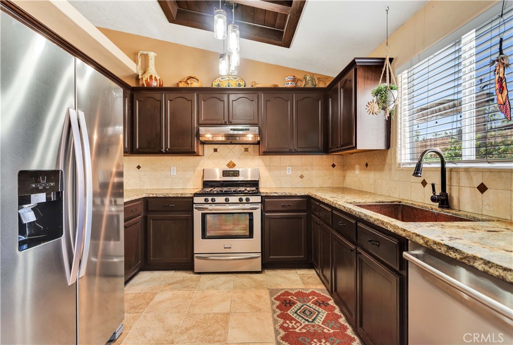 57490 Redondo Street Yucca Valley, CA 92284 - Photo 16 of 60 a kitchen with stainless steel appliances granite countertop a refrigerator sink and stove