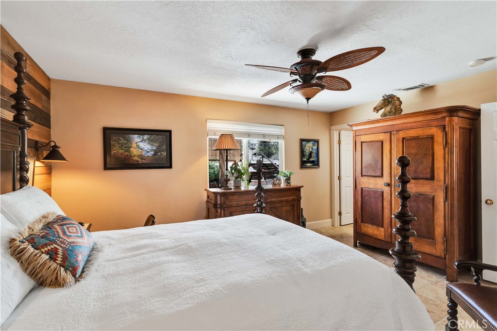 57490 Redondo Street Yucca Valley, CA 92284 - Photo 20 of 60 a bedroom with a large bed and a chandelier