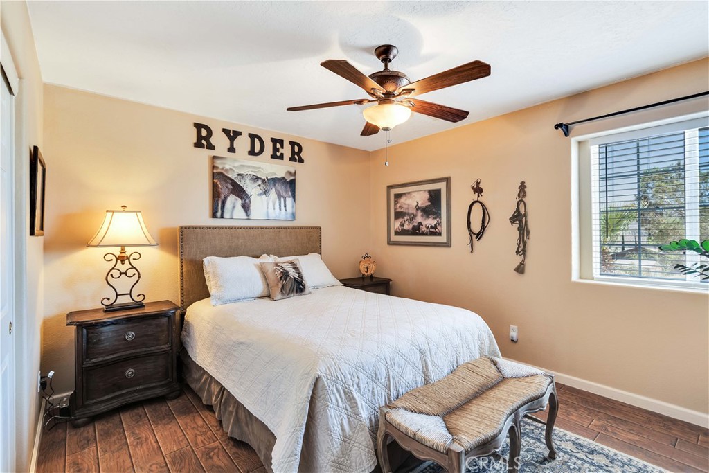 57490 Redondo Street Yucca Valley, CA 92284 - Photo 23 of 60 a bedroom with a bed and wooden floor