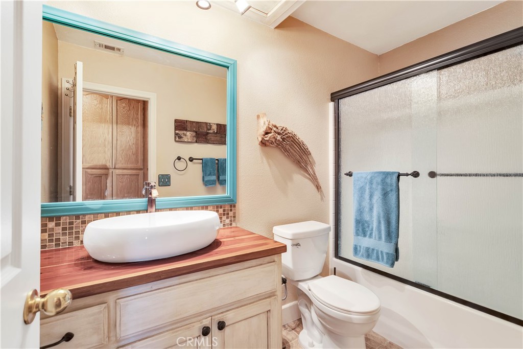 57490 Redondo Street Yucca Valley, CA 92284 - Photo 25 of 60 a bathroom with a sink a toilet a mirror and shower