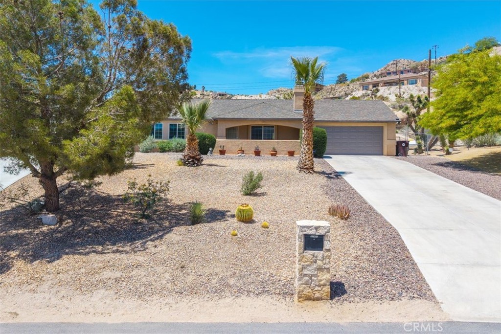 57490 Redondo Street Yucca Valley, CA 92284 - Photo 3 of 60 a front view of a house with a yard