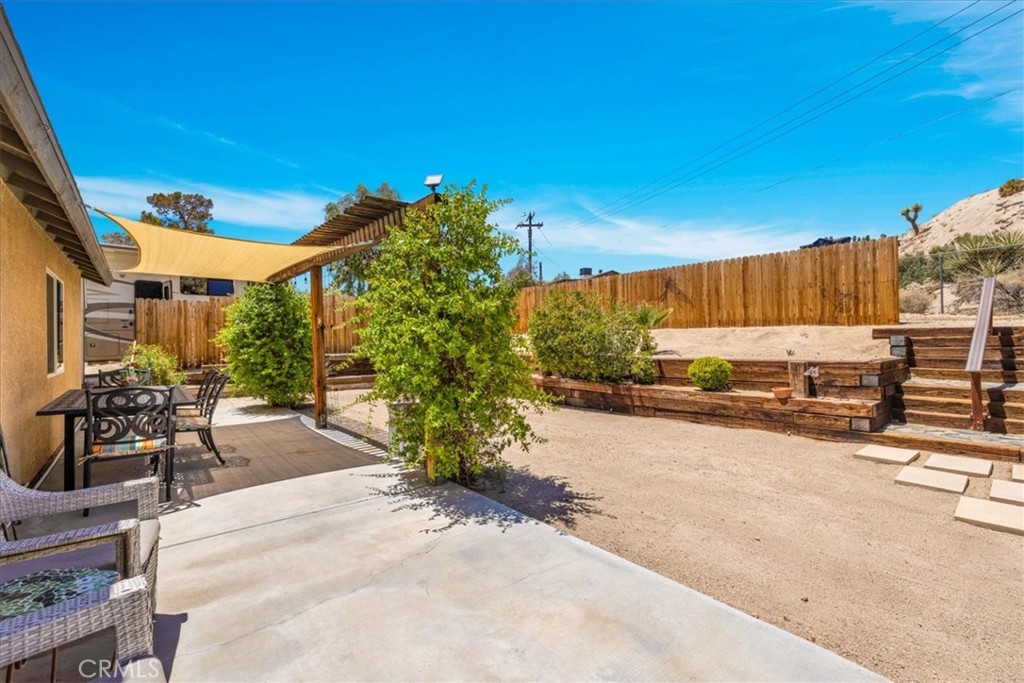 57490 Redondo Street Yucca Valley, CA 92284 - Photo 35 of 60 a view of a patio with table and chairs and potted plants